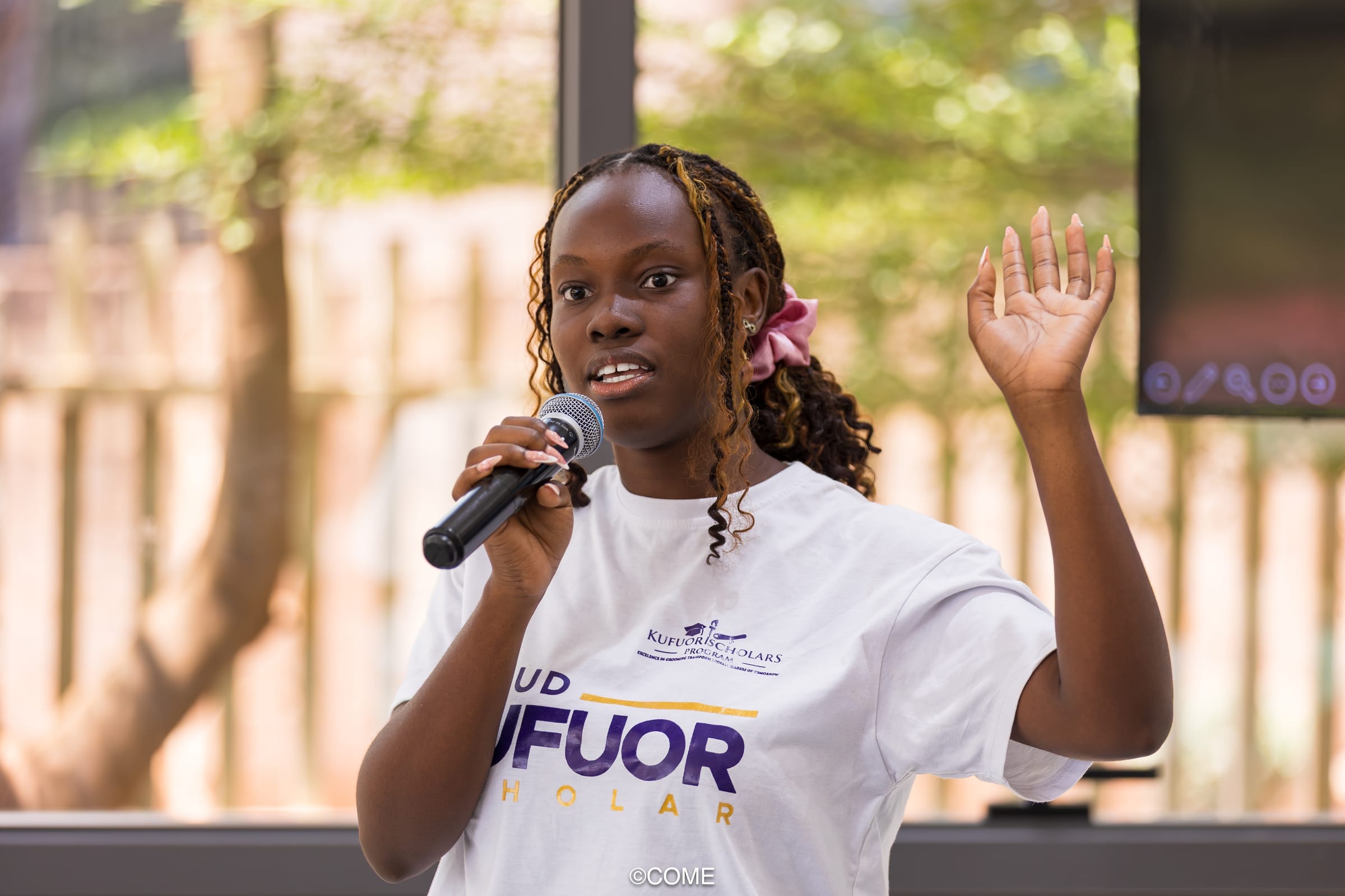 Young leader speaking into a microphone with confidence, representing LEAD leadership formation and voice.