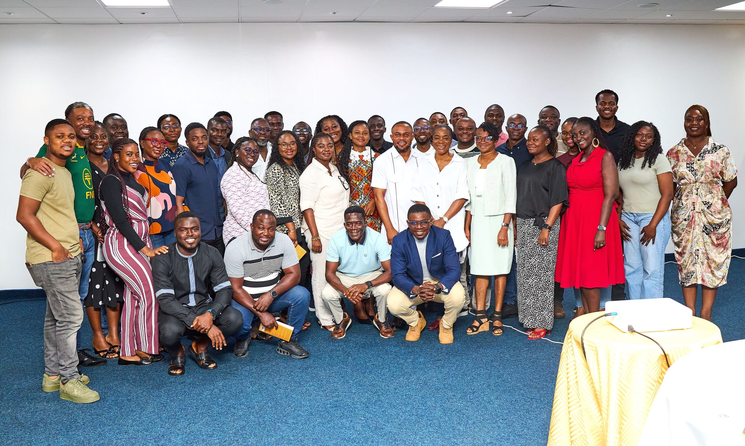 Training room with a podium and laptop; participants seated at tables in a seminar layout.
